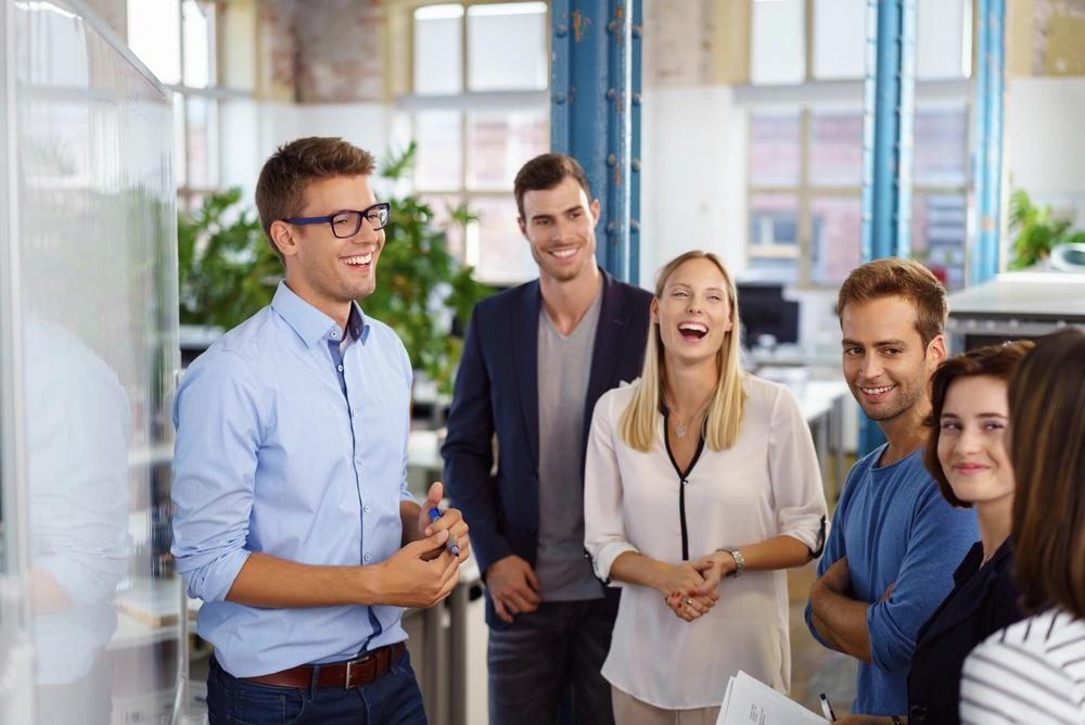 © contrastwerkstatt / Fotolia 6 junge Leute mit legerer Arbeitskleidung stehen zusammen in einem modernen Großraumbüro.